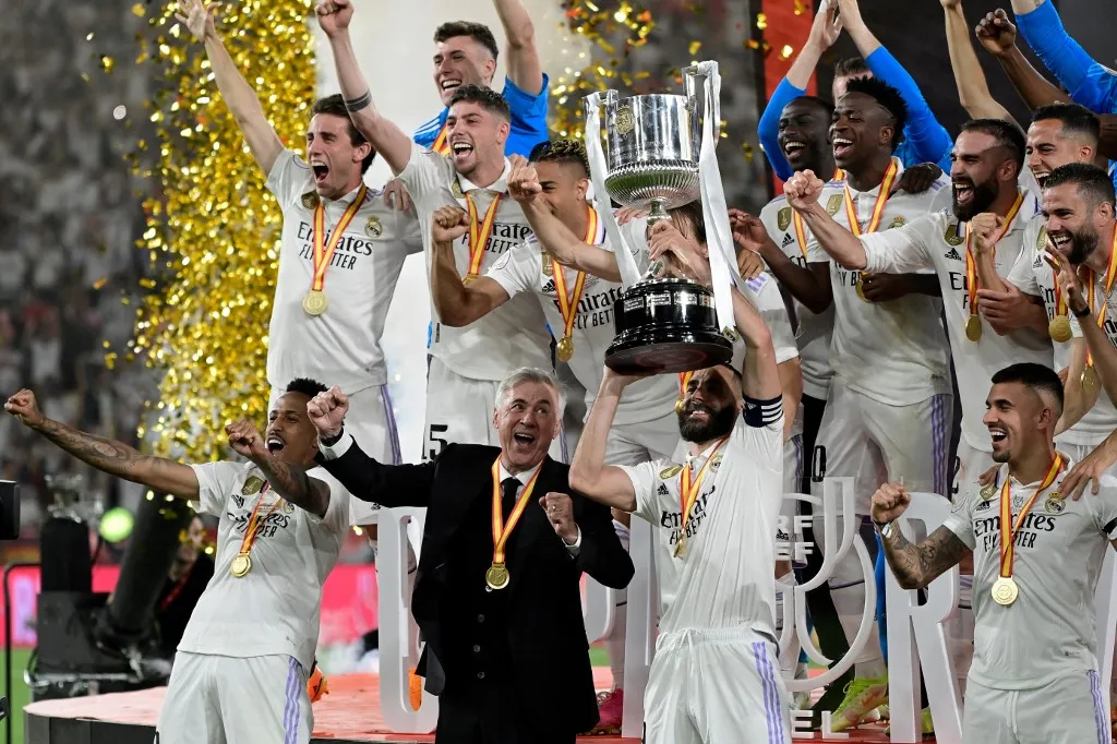 (FILES) Real Madrid's Italian coach Carlo Ancelotti (2nd-L) and his players celebrate with the trophy after winning the Spanish Copa del Rey (King's Cup) final football match between Real Madrid CF and CA Osasuna at La Cartuja stadium in Seville on May 6, 2023. Real Madrid coach Carlo Ancelotti will leave the club at the end of the season to take charge of the Brazil national team, the Brazilian Football Confederation announced on May 12, 2025. (Photo by ANDER GILLENEA / AFP)
