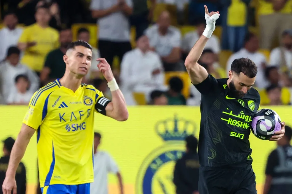 Nassr's Portuguese forward #7 Cristiano Ronaldo reacts as Ittihad's French forward #09 Karim Benzema celebrates scoring his team's first goal during the Saudi Pro League football match between Al-Nassr and Al-Ittihad at Al-Awwal Park in Riyadh on May 7, 2025. (Photo by Fayez NURELDINE / AFP)