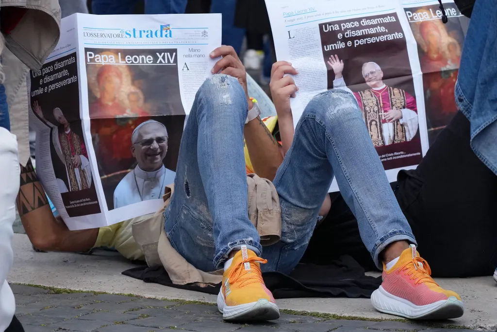 VATICAN CITY, VATICAN - MAY 18: Well-wishers read the newspaper ahead of the Inauguration Mass of Pope Leo XIV in St Peter's Square on May 18, 2025 in Vatican City, Vatican. Pope Leo XIV (formerly Cardinal Robert Francis Prevost) presided over his inauguration mass in St Peter's Square after his election on May 8th. (Photo by Christopher Furlong/Getty Images)