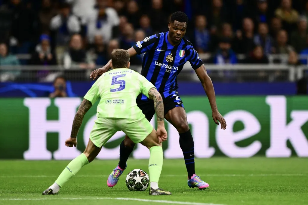 Inter Milan's Dutch defender #02 Denzel Dumfries (R)tries to dribble past Barcelona's Spanish defender #05 Inigo Martinez Berridi during the UEFA Champions League semi-final second leg football match between Inter Milan and FC Barcelona at the San Siro stadium in Milan on May 6, 2025. (Photo by Marco BERTORELLO / AFP)