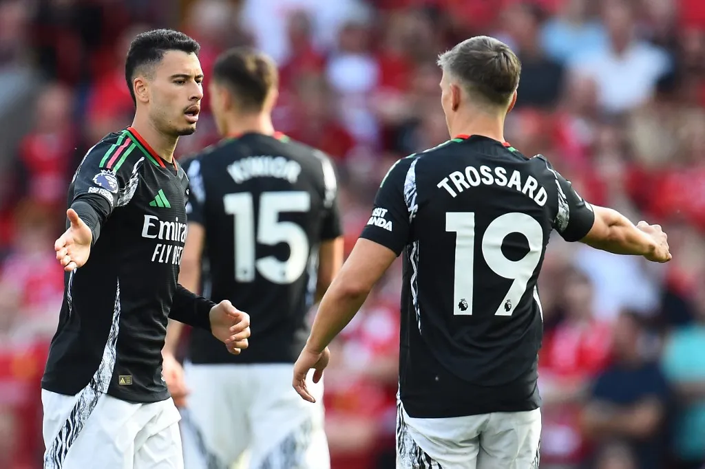 Arsenal's Brazilian midfielder #11 Gabriel Martinelli (L) celebrates with Arsenal's Belgian midfielder #19 Leandro Trossard (R) after scoring their first goal during the English Premier League football match between Liverpool and Arsenal at Anfield in Liverpool, north west England on May 11, 2025. (Photo by PETER POWELL / AFP) / RESTRICTED TO EDITORIAL USE. No use with unauthorized audio, video, data, fixture lists, club/league logos or 'live' services. Online in-match use limited to 120 images. An additional 40 images may be used in extra time. No video emulation. Social media in-match use limited to 120 images. An additional 40 images may be used in extra time. No use in betting publications, games or single club/league/player publications. / 