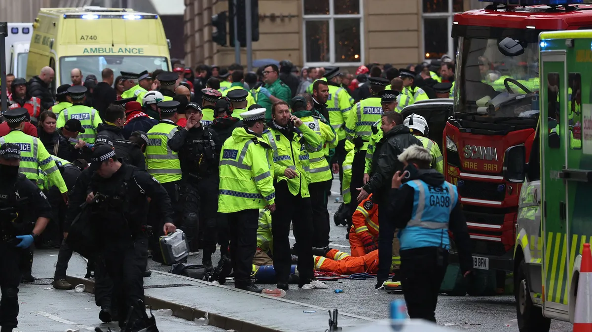 Members of the emergency services treat members of the public inside a Police cordon at the scene of an incident on Water Street, on the sidelines of an open-top bus victory parade for Liverpool's Premier League title win, in Liverpool, north-west England on May 26, 2025. (Photo by Darren Staples / AFP)