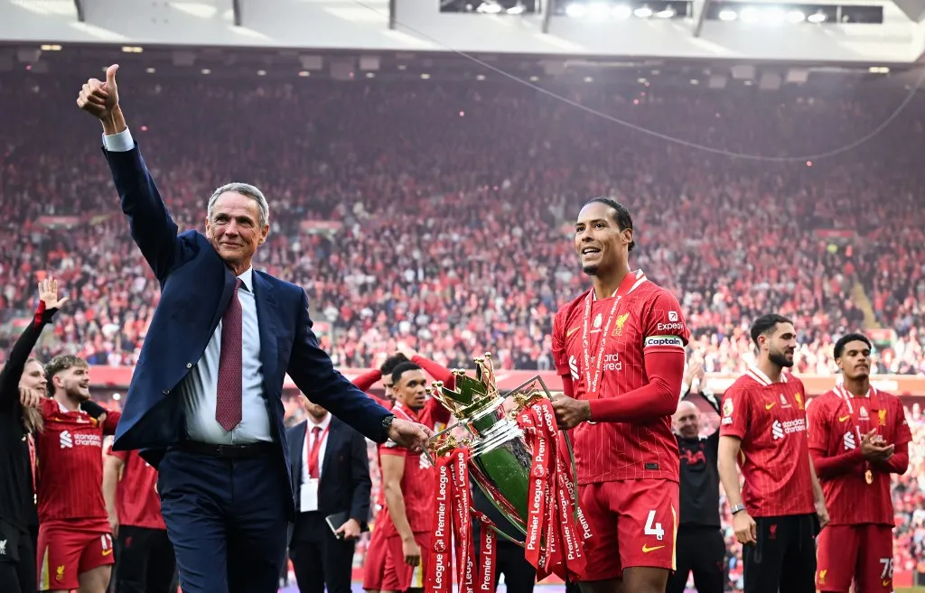 Liverpool's Dutch defender #04 Virgil van Dijk (R) and former player Alan Hansen (L) pose with the Premier League trophy at the end of the English Premier League football match between Liverpool and Crystal Palace at Anfield in Liverpool, north west England on May 25, 2025. Liverpool equalises 1 - 1 against Crystal Palace. (Photo by Paul ELLIS / AFP) / RESTRICTED TO EDITORIAL USE. No use with unauthorized audio, video, data, fixture lists, club/league logos or 'live' services. Online in-match use limited to 120 images. An additional 40 images may be used in extra time. No video emulation. Social media in-match use limited to 120 images. An additional 40 images may be used in extra time. No use in betting publications, games or single club/league/player publications. /