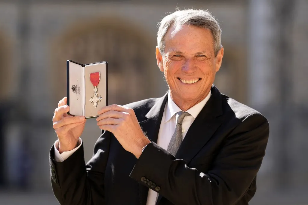 Former Scottish footballer Alan Hansen poses with their medal after being appointed a Member of the Order of the British Empire (MBE) during an Investiture ceremony at Windsor Castle, in Windsor, Berkshire, on March 18, 2025. (Photo by Andrew Matthews / POOL / AFP)