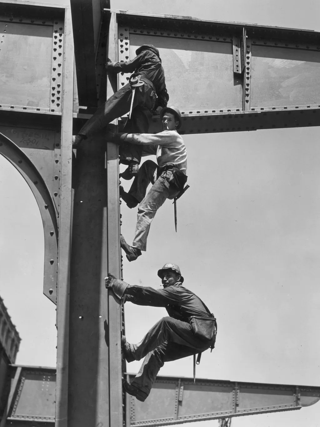 Az első felhőkarcolók építése,  circa 1935:  Three construction workers smoke while they climb the steel girders of a building under construction without a ladder.  (Photo by Mac Gramlich/Hulton Archive/Getty Images)