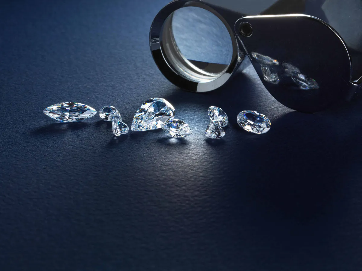 gyémántok, gyémántbánya, gyémánt, Close up of diamonds various cuts and sizes at workplace of diamond expert on blue background.Gyémántok az örökkévalóságnak