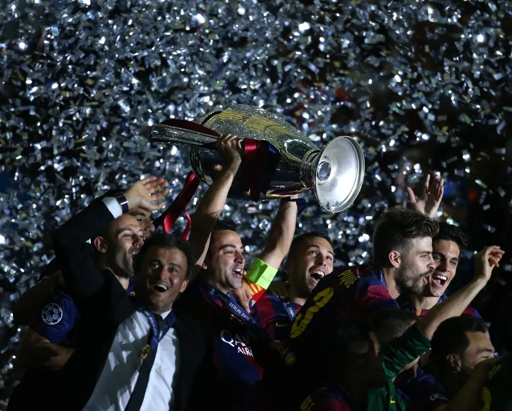 Barcelona's Xavi Hernandez (C)  lifts the trophy next to head coach Luis Enrique (L)  after winning the UEFA Champions League final soccer match between Juventus FC and FC Barcelona at Olympiastadion in Berlin, Germany, 06 June 2015. Photo: Kay Nietfeld/dpa (Photo by KAY NIETFELD / DPA / dpa Picture-Alliance via AFP)