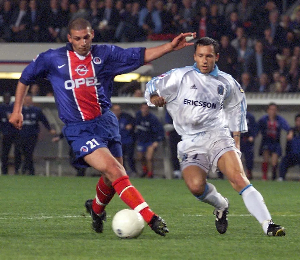 l'attaquant parisien Bruno Rodriguez (G) déborde le défenseur marseillais Patrick Blondeau et inscrit le but de la victoire, le 04 mai 1999 au Parc des Princes à Paris, lors du match Paris SG/Olympique de Marseille comptant pour la 32e journée du championnat de France de football de première division. Le Paris Saint-Germain s'impose 2 buts à 1.    (IMAGE ELECTRONIQUE) (Photo by JACQUES DEMARTHON / AFP)
