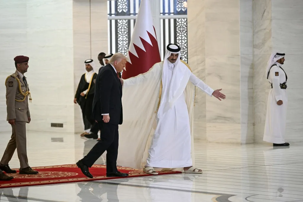 Qatar's Emir Sheikh Tamim bin Hamad al-Thani (R) receives US President Donald Trump in the Qatari capital Doha on May 14, 2025. Trump touched down at Hamad International Airport in Doha, with relations between the two governments in the spotlight over Qatar's offer to Trump of a $400 million luxury aircraft to serve as a new Air Force One and then pass into his personal use. (Photo by Brendan SMIALOWSKI / AFP)