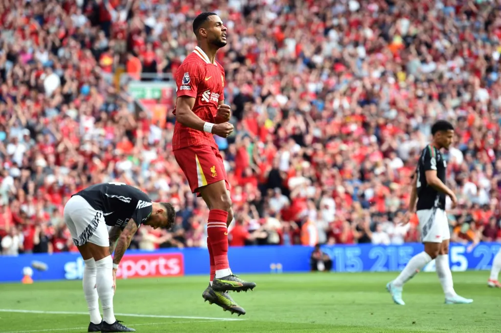 Liverpool's Dutch striker #18 Cody Gakpo celebrates after scoring the opening goal during the English Premier League football match between Liverpool and Arsenal at Anfield in Liverpool, north west England on May 11, 2025. (Photo by PETER POWELL / AFP) / RESTRICTED TO EDITORIAL USE. No use with unauthorized audio, video, data, fixture lists, club/league logos or 'live' services. Online in-match use limited to 120 images. An additional 40 images may be used in extra time. No video emulation. Social media in-match use limited to 120 images. An additional 40 images may be used in extra time. No use in betting publications, games or single club/league/player publications. / 