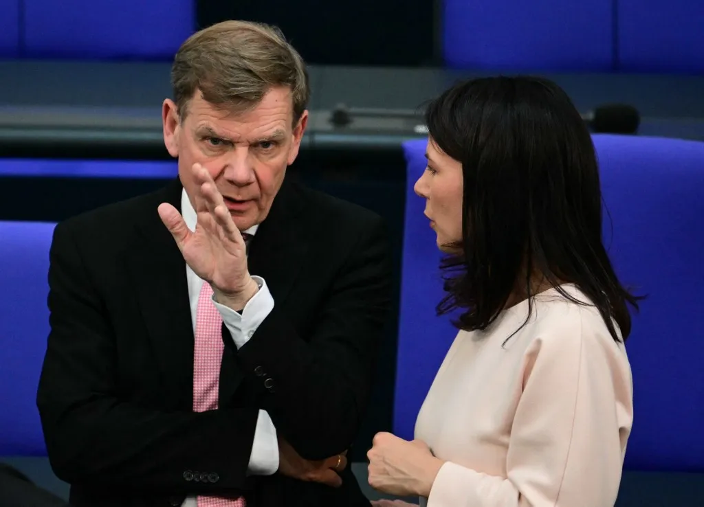 Designated German Foreign Minister Johann Wadephul (L) talks with outgoing German Foreign Minister Annalena Baerbock after the second round of voting during a session at the Bundestag (lower house of parliament), as MPs are to elect Germany's next Chancellor, in Berlin on May 6, 2025. German lawmakers voted for conservative leader Friedrich Merz to become chancellor Tuesday in a second-round vote after he suffered a shock defeat in the initial ballot. (Photo by Tobias SCHWARZ / AFP)