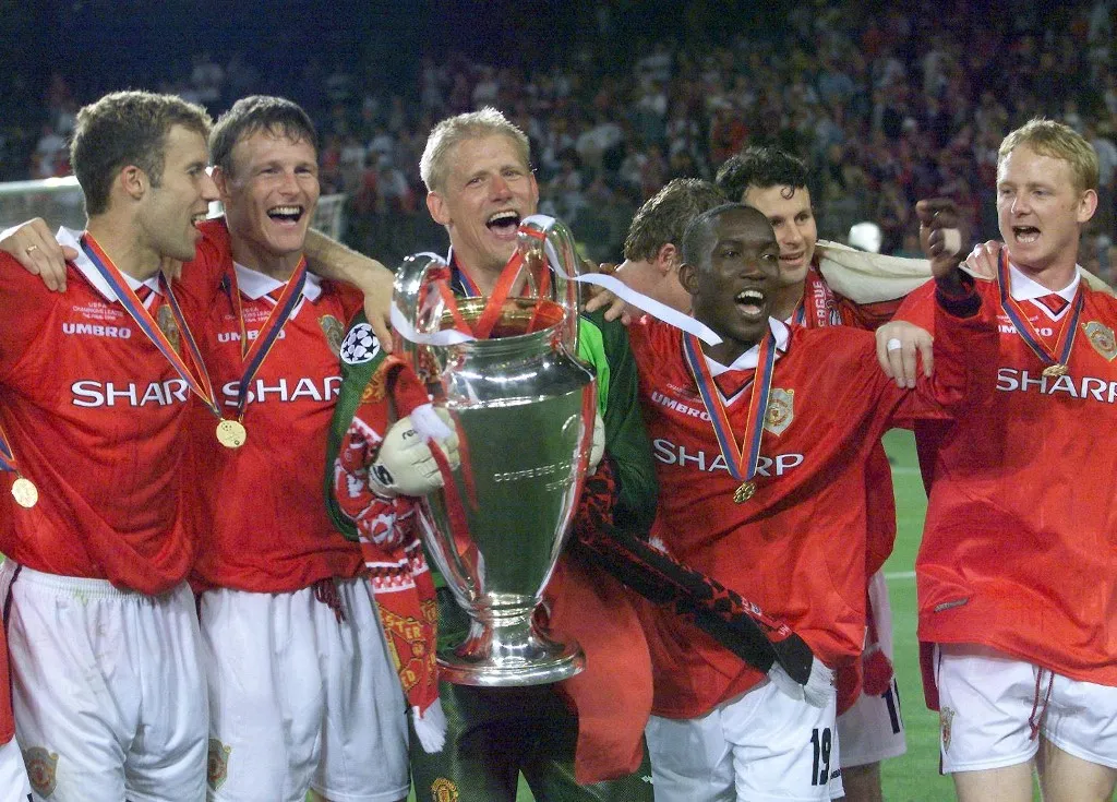 players of Manchester United jubilate with the trophee after winning the final of the soccer Champions League against Bayern Munich, 26 May 1999 at the Camp Nou Stadium in Barcelona. Manchester United won 2-1.
(ELECTRONIC IMAGE) (Photo by Eric CABANIS / AFP)