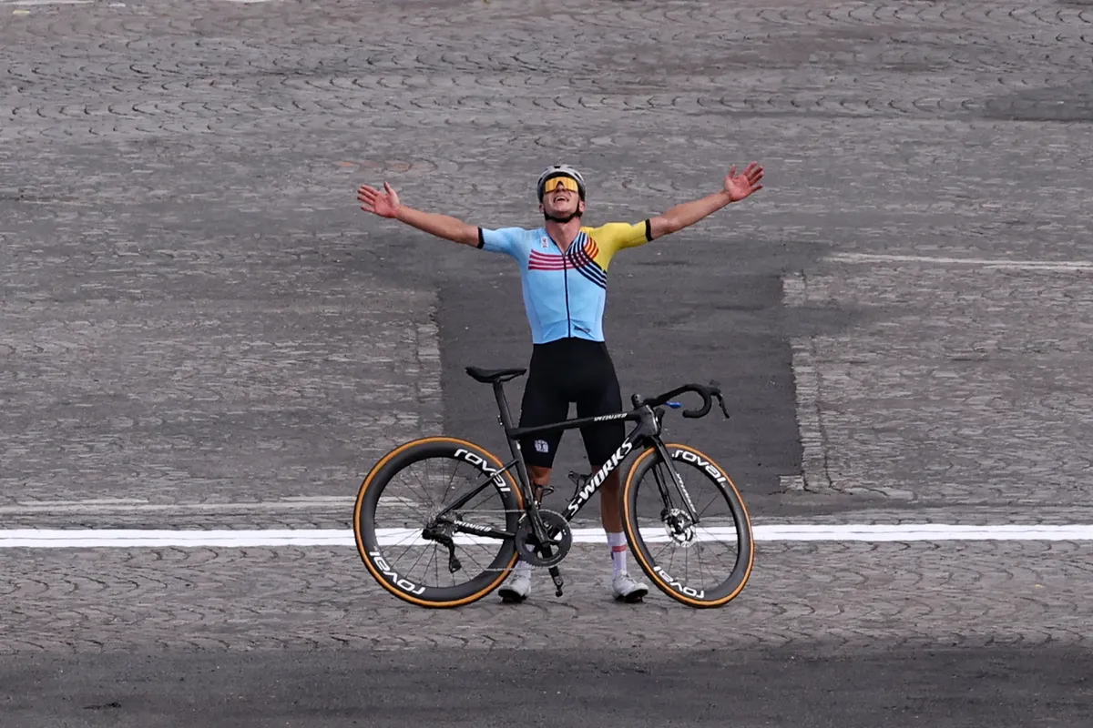 Belgium's Remco Evenepoel celebrates as he crosses the finish line to win the men's cycling road race during the Paris 2024 Olympic Games in Paris, on August 3, 2024. (Photo by David GRAY / AFP)