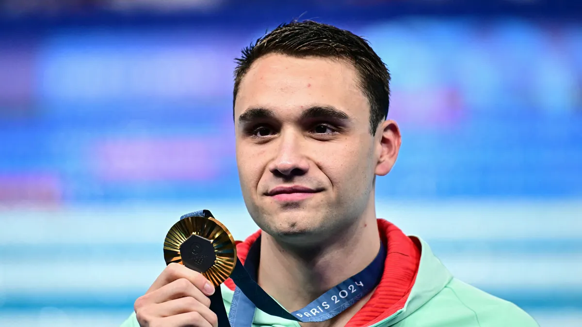 Milák Kristóf, Gold medallist Hungary's Kristof Milak stands on the podium of the men's 100m butterfly swimming event during the Paris 2024 Olympic Games at the Paris La Defense Arena in Nanterre, west of Paris, on August 3, 2024. (Photo by Manan VATSYAYANA / AFP)