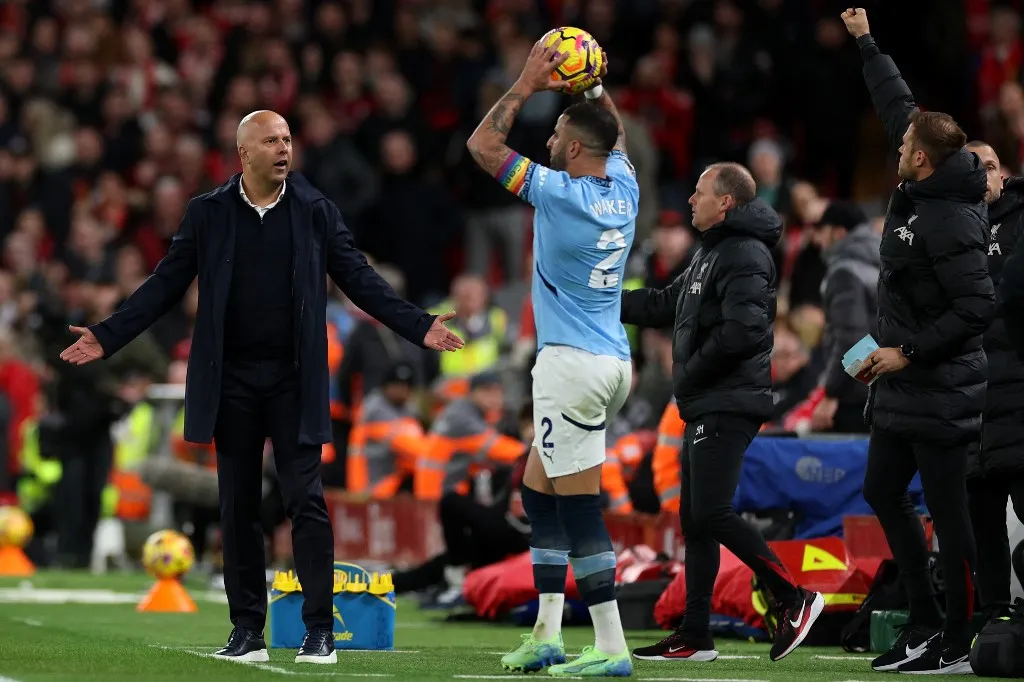 Liverpool's Dutch manager Arne Slot (L) reacts and Manchester City's English defender #02 Kyle Walker prepares to take a throw in during the English Premier League football match between Liverpool and Manchester City at Anfield in Liverpool, north west England on December 1, 2024. (Photo by Adrian Dennis / AFP) / RESTRICTED TO EDITORIAL USE. No use with unauthorized audio, video, data, fixture lists, club/league logos or 'live' services. Online in-match use limited to 120 images. An additional 40 images may be used in extra time. No video emulation. Social media in-match use limited to 120 images. An additional 40 images may be used in extra time. No use in betting publications, games or single club/league/player publications. / 