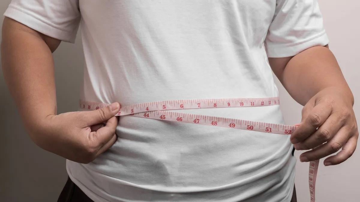 overweight or obese woman shows fat deposits in the abdomen. healthcare, medicine concept. she is dieting and losing weight.