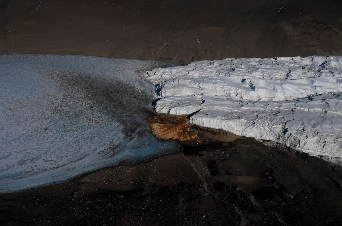 This general view shows an aerial view of Blood Falls and the Taylor Glacier near McMurdo Station on November 11, 2016 while in flight during a visit by US Secretary of State John Kerry to Antarctica. Kerry is travelling to Antarctica, New Zealand, Oman, the United Arab Emirates, Morocco and will attend the APEC summit in Peru later in the month. (Photo by Mark RALSTON / POOL / AFP)