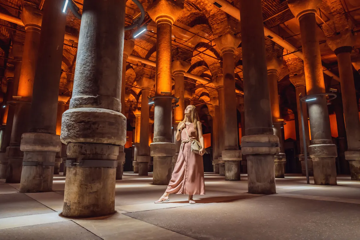 Woman tourist enjoying Beautiful cistern in Istanbul. Cistern - underground water reservoir build in 6th century, Istanbul, Turkey, Turkiye
