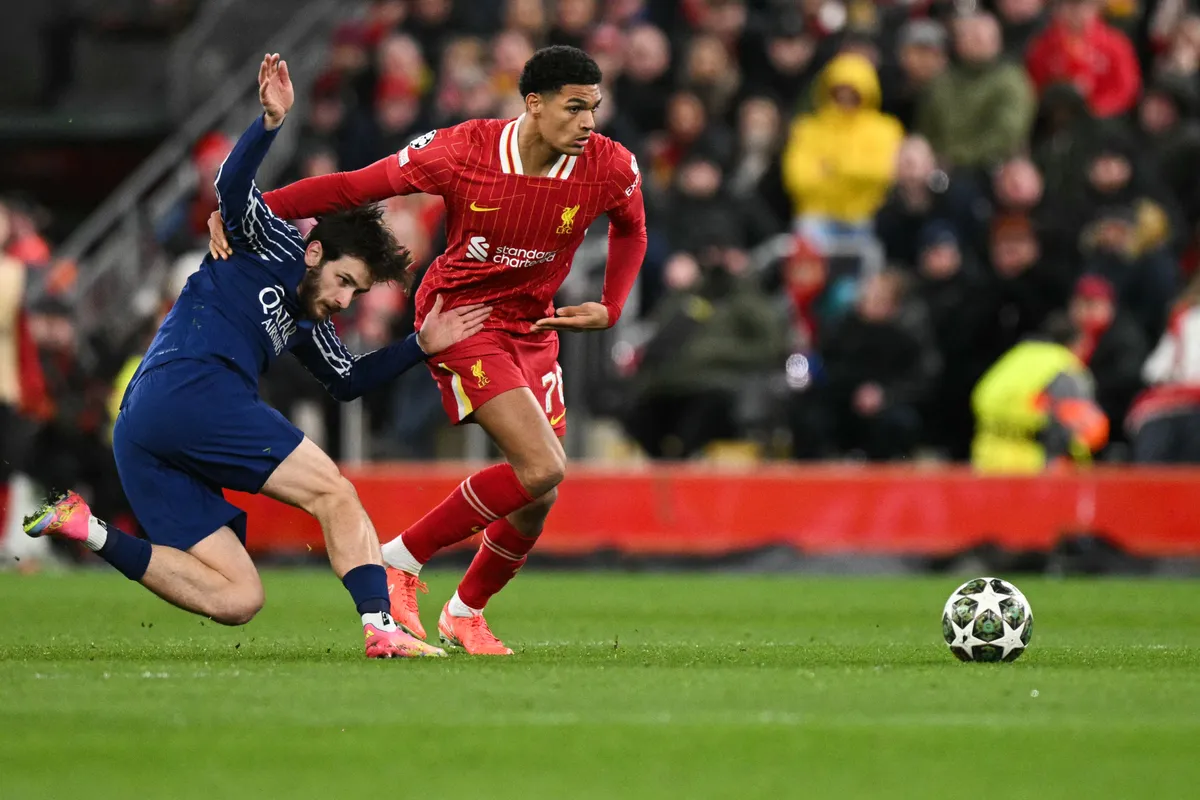 Paris Saint-Germain's Georgian forward #07 Khvicha Kvaratskhelia (L) fights for the ball with Liverpool's English defender #78 Jarell Quansah during the last 16 second leg UEFA Champions League football match between Liverpool and Paris Saint-Germain (PSG) at Anfield in Liverpool, north west England on March 11, 2025. (Photo by Oli SCARFF / AFP)