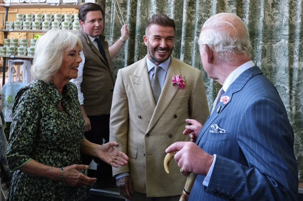 David Beckham Kamilla királyné és III. Károly király társaságában Britain's Queen Camilla (L) and Britain's King Charles III (R) speak with businessman and retired football player David Beckham as they visit the preview day at the RHS Chelsea Flower show, in London, on May 19, 2025.  (Photo by Toby Melville / POOL / AFP)