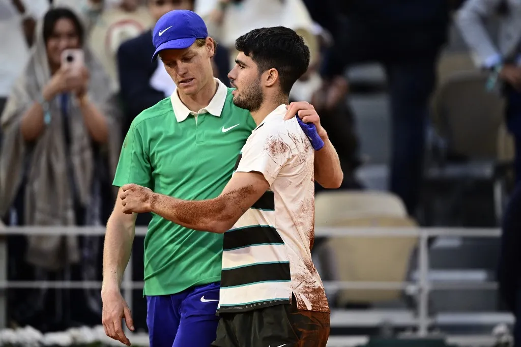 Winner Spain's Carlos Alcaraz (R) cheers Italy's Jannik Sinner at the end of their men's singles final match on day 15 of the French Open tennis tournament on Court Philippe-Chatrier at the Roland-Garros Complex in Paris on June 8, 2025. (Photo by JULIEN DE ROSA / AFP)