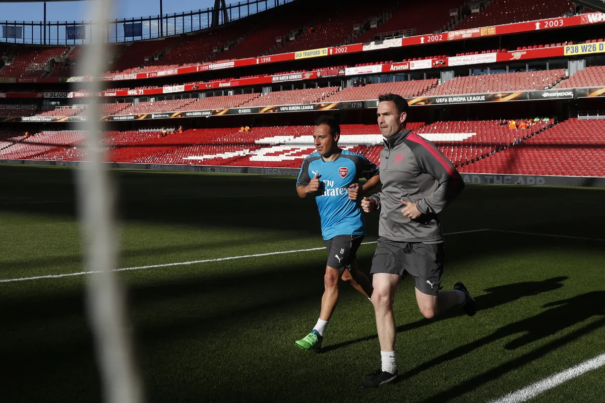 Arsenal's Spanish midfielder Santi Cazorla (L) trains on the pitch ahead of the UEFA Europa League first leg semi-final football match  between Arsenal and Atletico Madrid at the Emirates Stadium in London on April 26, 2018. (Photo by Adrian DENNIS / AFP)