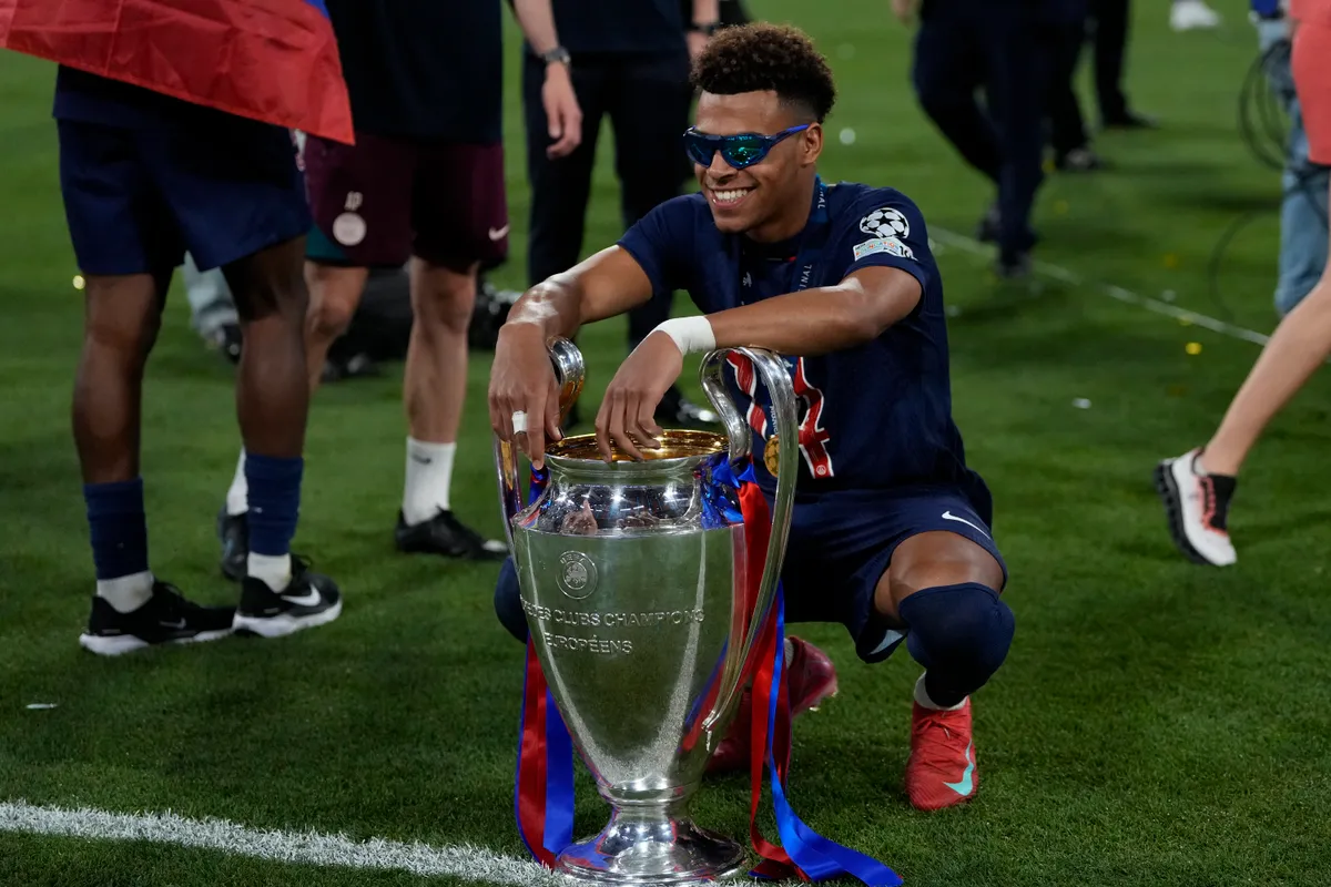MUNICH, GERMANY - MAY 31: Desire Doue left winger of PSG and France celebrates with the trophy after winning the UEFA Champions League Final 2025 between Paris Saint-Germain and FC Internazionale Milano at Allianz Arena on May 31, 2025 in Munich, Germany. (Photo by Jose Breton/Pics Action/NurPhoto) (Photo by Jose Breton / NurPhoto / NurPhoto via AFP)