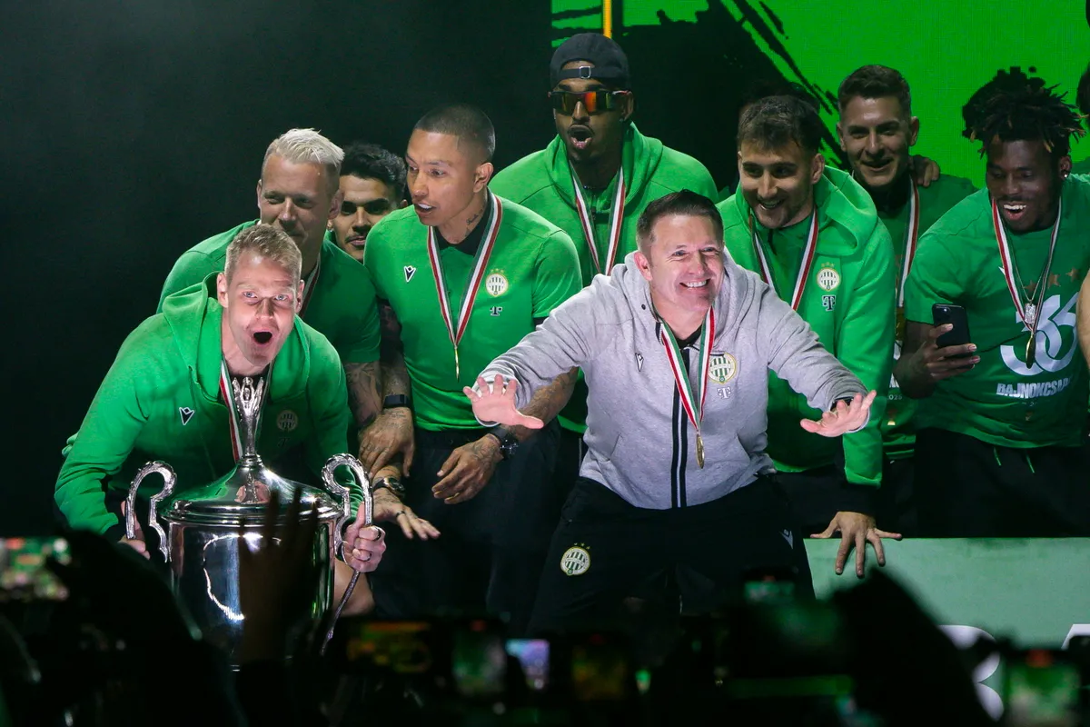 Fradi Budapest, 2025. május 25.
Robbie Keane vezetőedző (j4) és Dibusz Dénes csapatkapitány (b) a trófeával a bajnok Ferencváros labdarúgócsapatának éremátadási ünnepségén a Groupama Arénánál 2025. május 25-én. A Ferencváros sorozatban a hetedik, összességében pedig a 36. bajnoki címét szerezte meg.
MTI/Hegedüs Róbert