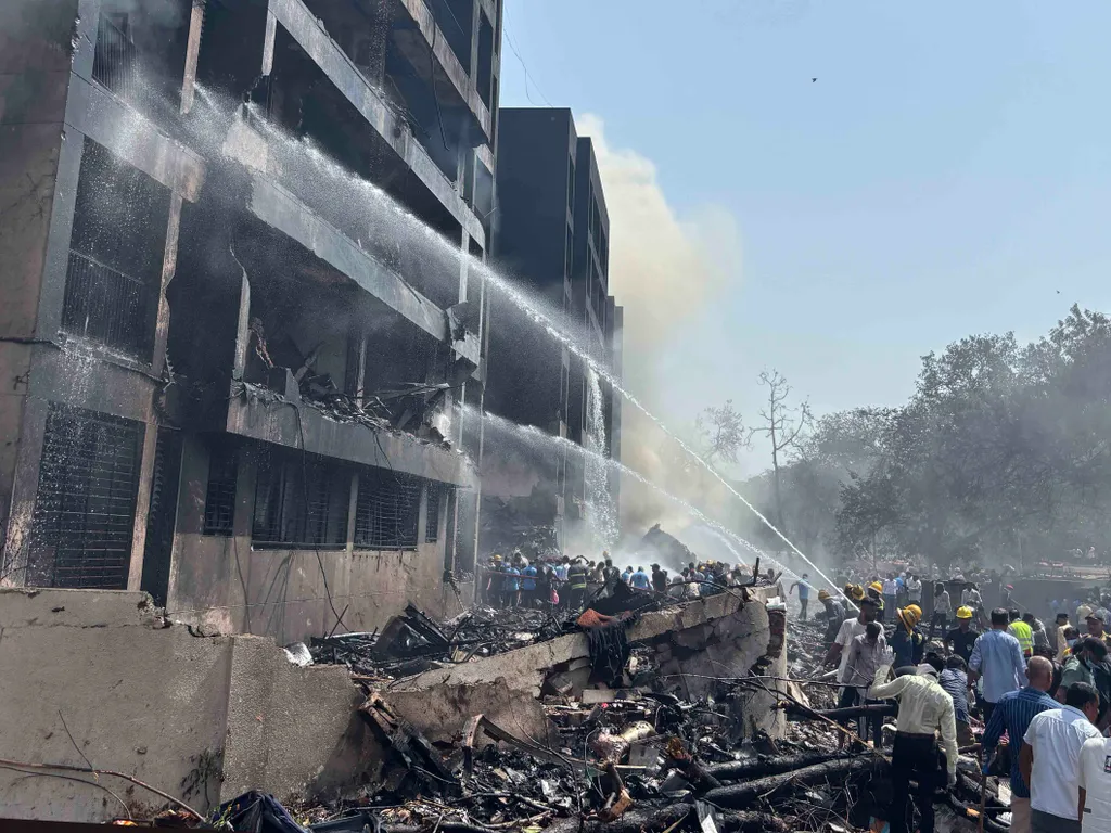 utasszállító repülőgép repülőgép, baleset, lezuhant, repülőgépbaleset, India, Air India, Air India 171-es járat, 2025.06.12., Indiarepülőgépbaleset, Ahmadábád, 2025. június 12.
Tűzoltók locsolnak egy lakóépületet a baleset helyszínén a Gudzsarát állambeli