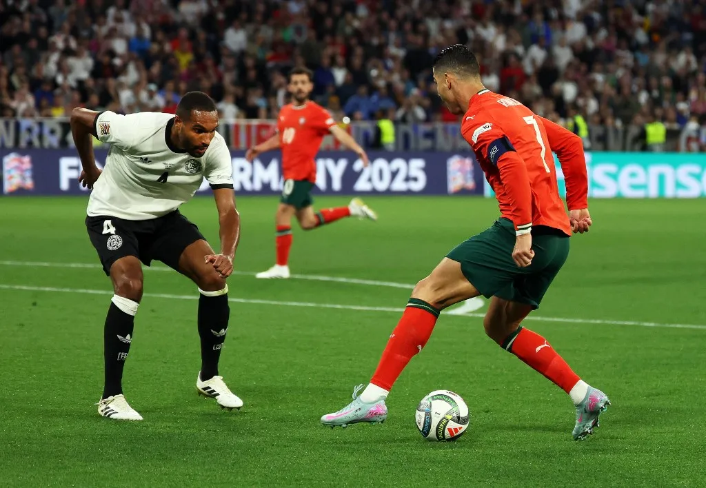 04 June 2025, Bavaria, Munich: Soccer: Nations League A, Germany - Portugal, play-off round, semi-final, Football Arena Munich, Germany's Jonathan Tah (l) and Portugal's Cristiano Ronaldo fight for the ball. Photo: Christian Charisius/dpa (Photo by CHRISTIAN CHARISIUS / dpa Picture-Alliance via AFP)