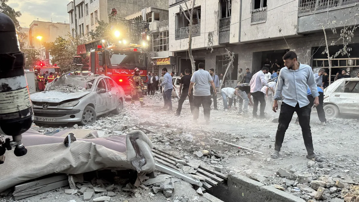 People and first-responders gather outside a building that was hit by an Israeli strike in Tehran on June 13, 2025. Israel hit about 100 targets in Iran on June 13, including nuclear facilities and military command centres and killing senior figures including the armed forces chief and top nuclear scientists, földgáz