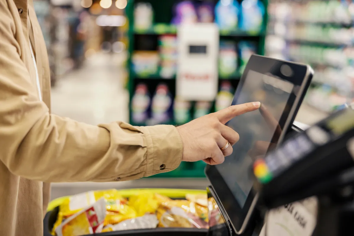 hatalmas áruházi balhé, Hand of a man at self-service checkout in supermarket.