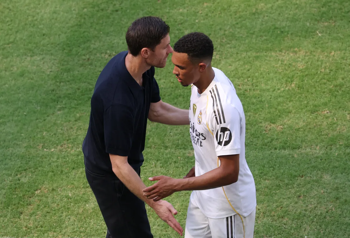 MIAMI GARDENS, FLORIDA - JUNE 18: Trent Alexander-Arnold #12 of Real Madrid C. F. greets Xabi Alonso, Head Coach of Real Madrid C. F., on the sidelines during the FIFA Club World Cup 2025 group H match between Real Madrid CF and Al Hilal at Hard Rock Stadium on June 18, 2025 in Miami Gardens, Florida.   Sandra Montanez/Getty Images/AFP (Photo by Sandra Montanez / GETTY IMAGES NORTH AMERICA / Getty Images via AFP)