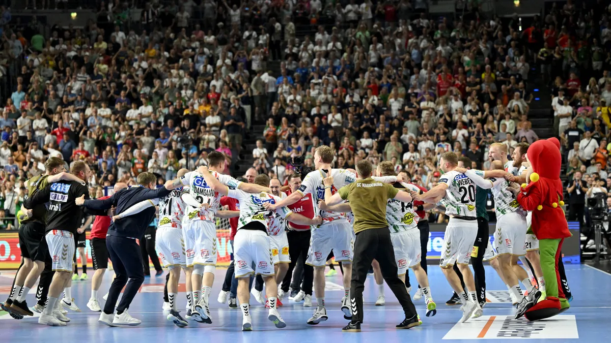 15 June 2025, North Rhine-Westphalia, Cologne: Handball: Champions League, Füchse Berlin - SC Magdeburg, final round, final four, final, Lanxess Arena. Magdeburg's players, coaches and support staff celebrate the victory. Photo: Marius Becker/dpa (Photo by MARIUS BECKER / dpa Picture-Alliance via AFP)