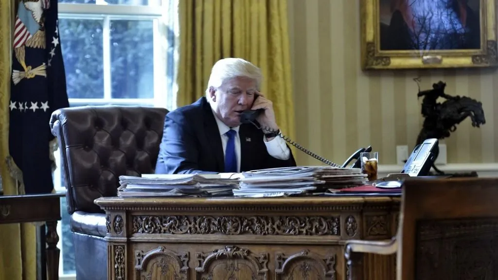 US President Donald Trump speaks on the phone with Russia's President Vladimir Putin from the Oval Office of the White House on January 28, 2017, in Washington, DC. (Photo by MANDEL NGAN / AFP)