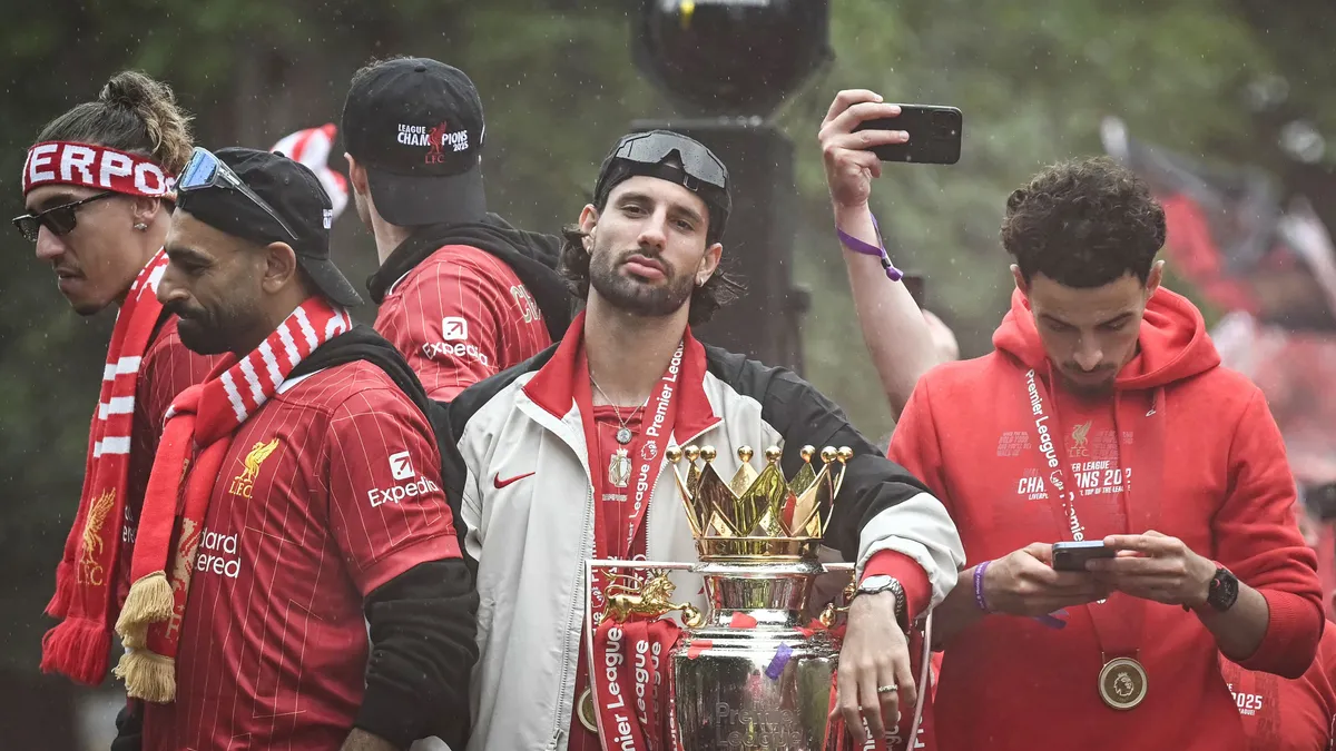 Szoboszlai, Liverpool's Hungarian midfielder #08 Dominik Szoboszlai celebrates with the Premier League trophy during an open-top bus victory parade for Liverpool's Premier League title win, in Liverpool, north-west England on May 26, 2025. (Photo by Paul ELLIS / AFP)