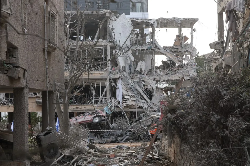 Damaged buildings and vehicles are seen in the Israeli city of Ramat Gan near Tel Aviv on June 14, 2025, caused by the fall of a missile fired the day before by Iran. The UN chief called for Israel and Iran to halt their escalating conflict, after the two countries exchanged a barrage of missiles. (Photo by Jack GUEZ / AFP)