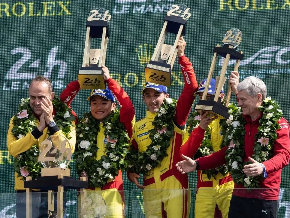 Le Mans, (From L) AF Corse's Italian team principal Amato Ferrari, AF Corse's Chinese driver Yifei Ye, AF Corse's Polish driver Robert Kubica, AF Corse's British driver Philip Hanson and Global Head of Ferrari Endurance and Corse Clienti Antonello Coletta celebrate with the trophie son the podium after their victory in the 24 Hours of Le Mans 2025, at the Le Mans circuit, north-western France on June 15, 2025. (Photo by Fred TANNEAU / AFP)