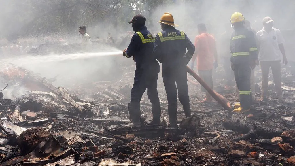 Firefighters work at the site where Air India flight 171 crashed in a residential area near the airport in Ahmedabad on June 12, 2025. The London-bound passenger plane crashed on June 12 in India's western city of Ahmedabad with 242 on board, aviation officials said in what the airline called a "tragic accident". (Photo by Sam PANTHAKY / AFP)