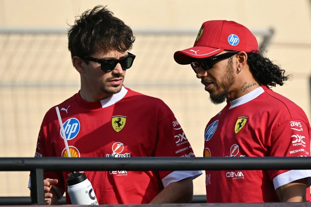 Ferrari's Monegasque driver Charles Leclerc and Ferrari's British driver Lewis Hamilton talk as they take part in the drivers parade for the Bahrain Formula One Grand Prix at the Bahrain International Circuit in Sakhir on April 13, 2025. (Photo by Andrej ISAKOVIC / AFP)