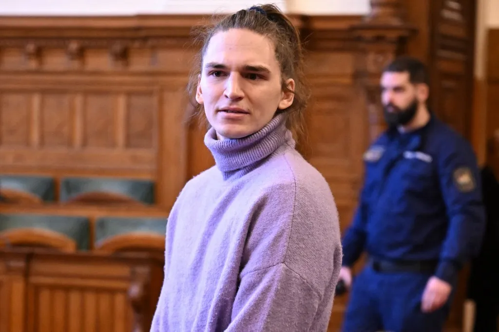 The defendant, German anti-fascist activist Maja T, reacts after arrival for a preliminary court hearing in Budapest on February 21, 2025 for allegedly participating in attacks against presumed neo-Nazis on the streets of the Hungarian capital. The case sparked uproar in Germany, with the country's top court saying the extradition order for the suspect, who identifies as non-binary, had failed to take into account potentially dangerous prison conditions in Hungary, especially for LGBTQ people. The defendant is accused of four counts of attempted assault as part of a criminal organisation aiming to "send a deterrent message to members of extreme-right movements" by "inflicting various life-threatening injuries" according to a court statement. (Photo by Attila KISBENEDEK / AFP)