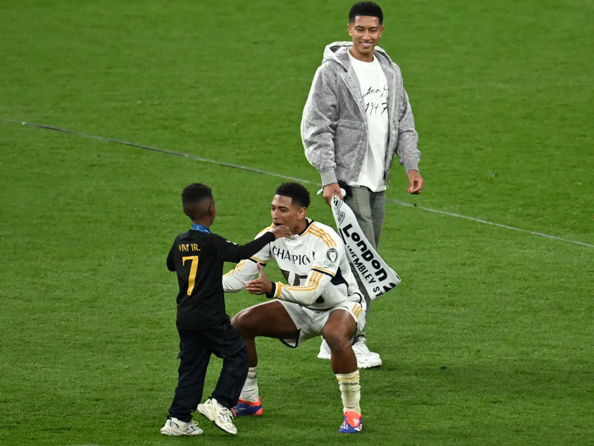 Real Madrid's English midfielder #05 Jude Bellingham celebrates with family members including his brother Jobe (R) after the UEFA Champions League final football match between Borussia Dortmund and Real Madrid, at Wembley stadium, in London, on June 1, 2024. (Photo by JUSTIN TALLIS / AFP)