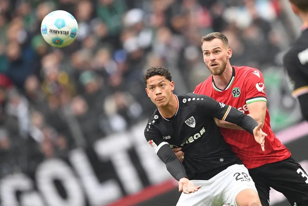 26 January 2025, Lower Saxony, Hanover: Soccer: Bundesliga 2, Hannover 96 - Preußen Münster, Matchday 19, Heinz von Heiden-Arena. Münster's András Németh (l) plays against Hannover's Boris Tomiak. Photo: Swen Pförtner/dpa - IMPORTANT NOTE: In accordance with the regulations of the DFL German Football League and the DFB German Football Association, it is prohibited to utilize or have utilized photographs taken in the stadium and/or of the match in the form of sequential images and/or video-like photo series. (Photo by Swen Pförtner / dpa Picture-Alliance via AFP)
