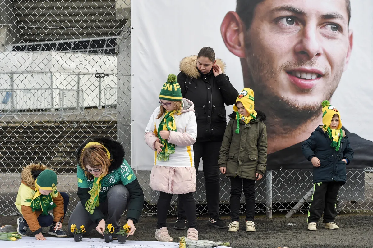 People and children lay flowers as they pay hommage to Nantes' Argentinian forward Emilianio Sala, who died one year ago in a plane crash, ahead of the French L1 football match between FC Nantes and Bordeaux in front of the La Beaujoire stadium in Nantes, western France, on January 26, 2020. The 28-year-old striker was killed when the small plane taking him to join the then Premier League club Cardiff after being bought from Nantes crashed off the Channel island of Guernsey. (Photo by Sebastien SALOM-GOMIS / AFP)