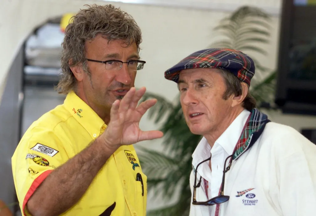 Jordan-Mugen Honda team director Eddie Jordan (L) talks with Stewart-Ford team director Jackie Stewart in the paddocks of the Hungaroring racetrack in Budapest during the first free practice session, 13 August 1999 two days before the Hungarian Formula One Grand prix. (ELECTRONIC IMAGE) (Photo by Patrick HERTZOG / AFP)