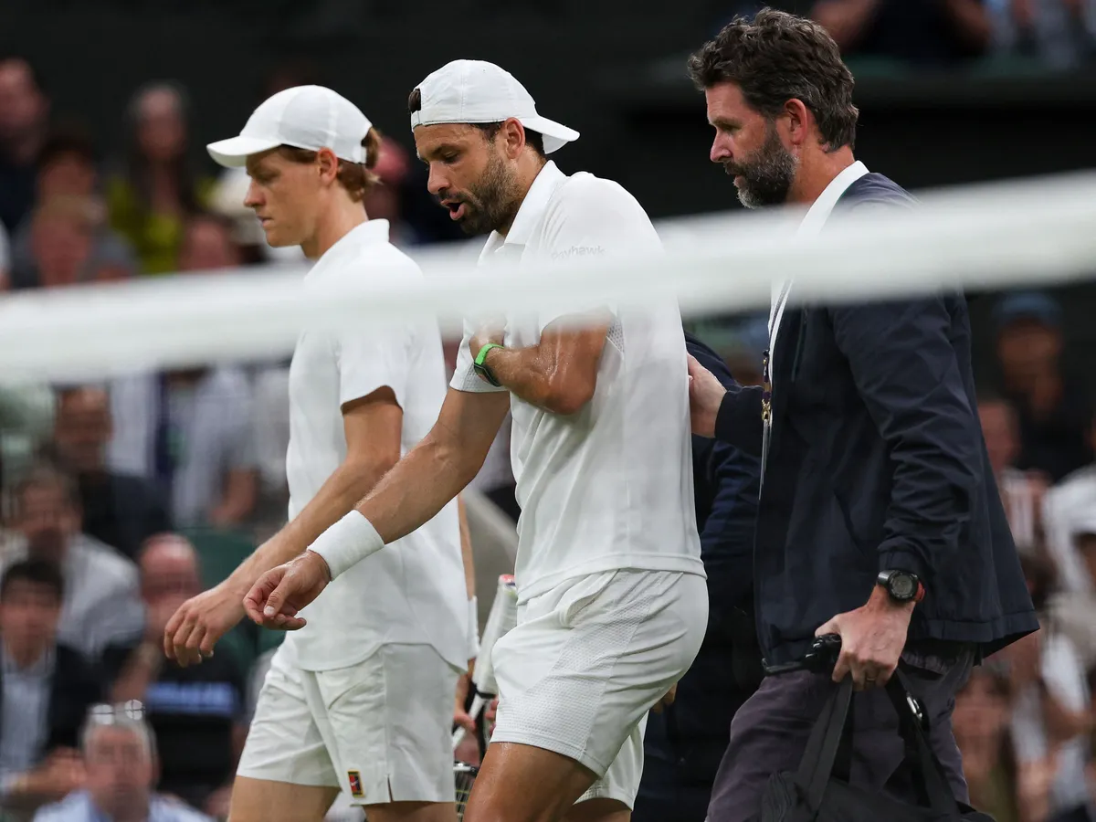 Bulgaria's Grigor Dimitrov (C) reacts as he walks next to Italy's Jannik Sinner (L) and medical staff after getting injured during the men's singles fourth round tennis match on the eighth day of the 2025 Wimbledon Championships at The All England Lawn Tennis and Croquet Club in Wimbledon, southwest London, on July 7, 2025. (Photo by Adrian Dennis / AFP) / RESTRICTED TO EDITORIAL USE