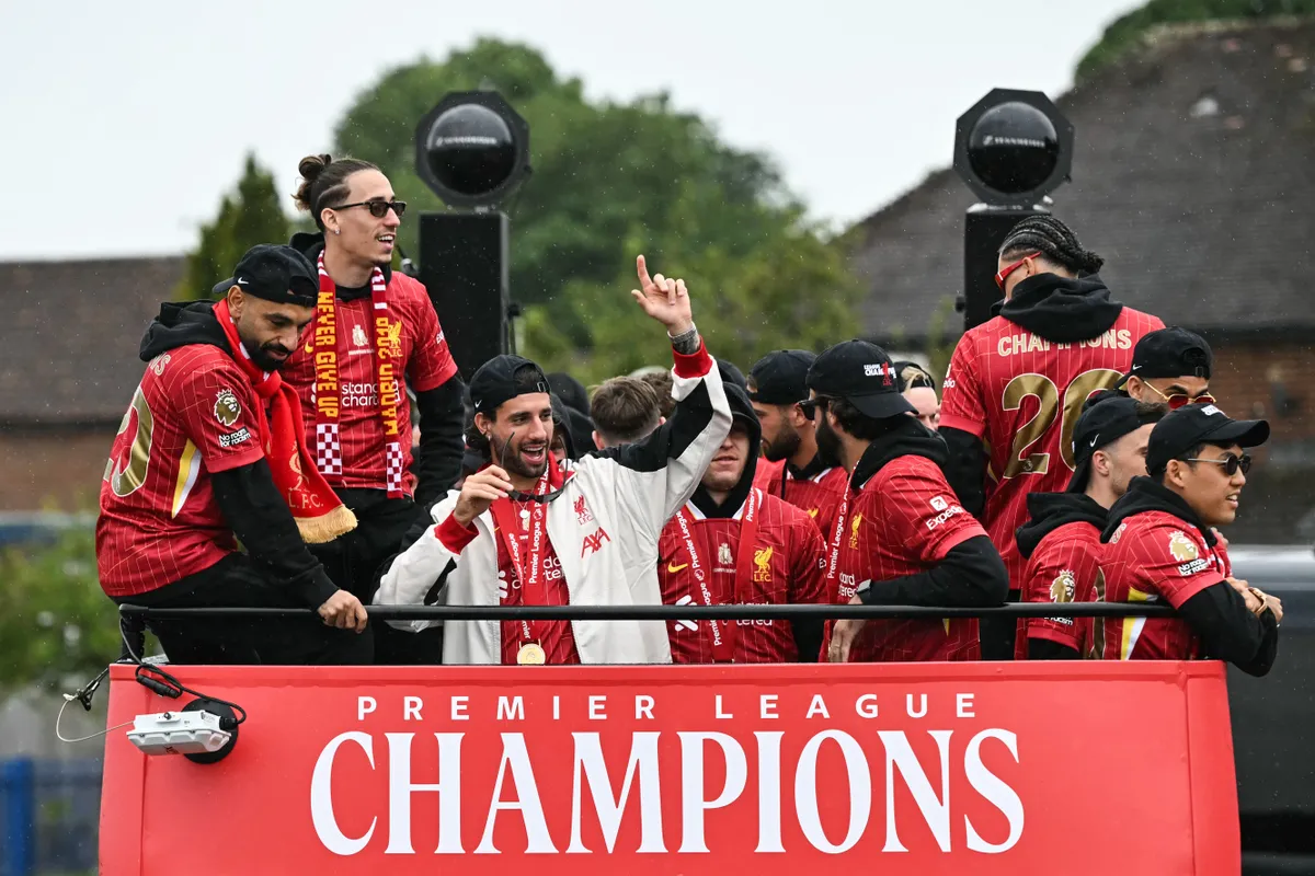 (from L) Liverpool's Egyptian striker #11 Mohamed Salah; Liverpool's Greek defender #21 Kostas Tsimikas and Liverpool's Hungarian midfielder #08 Dominik Szoboszlai get ready for the open-top bus victory parade for Liverpool's Premier League title win, in Liverpool, north-west England on May 26, 2025. (Photo by Paul ELLIS / AFP)