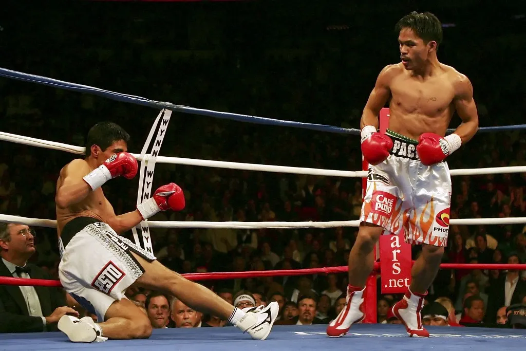 LAS VEGAS - NOVEMBER 18:  (R-L) Manny Pacquiao of the Philippines watches as Erik Morales of Mexico is knocked down during the second round during their super featherweight bout at the Thomas & Mack Center on November 18, 2006 in Las Vegas, Nevada. Pacquaio knocked out Morales in the third round for the victory. (Photo by Jed Jacobsohn/Getty Images) *** Local Caption *** Manny Pacquaio;Erik Morales (Photo by Jed Jacobsohn / Getty Images North America / Getty Images via AFP)