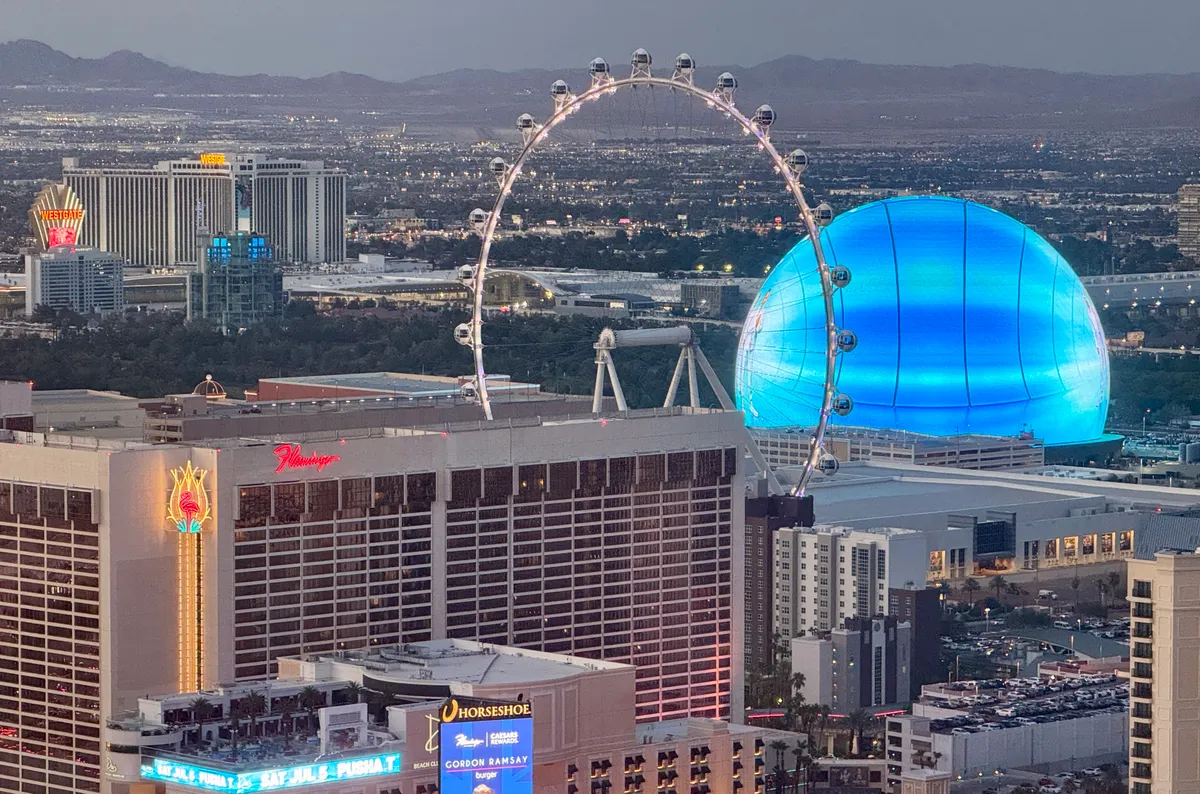 The High Roller Observation Wheel and the MSG (Madison Square Garden) Sphere lit up in blue are seen in Las Vegas, Nevada on July 3, 2025. (Photo by Daniel SLIM / AFP), foci-vb