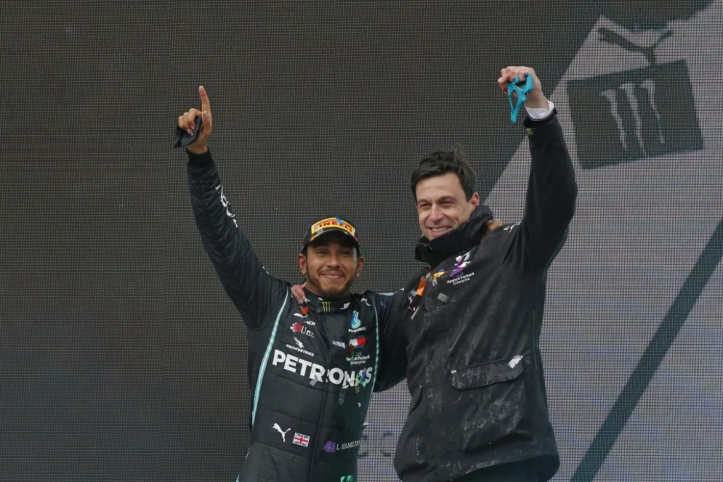Mercedes' British driver Lewis Hamilton (L) and Team Principal Toto Wolff (R) wave on the podium after winning the Turkish Formula One Grand Prix at the Intercity Istanbul Park circuit in Istanbul on November 15, 2020. (Photo by Kenan Asyali / POOL / AFP)